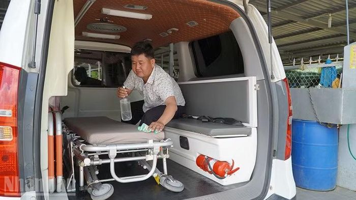 Anh Nguyễn Văn Hảo vệ sinh xe chuyển bệnh miễn phí. (Ảnh: HỮU NGHĨA)