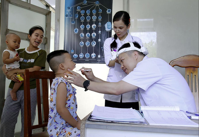 Bác sĩ chuyên khoa nhi của Bệnh viện Bạch Mai khám răng cho "công dân nhí'' trên đảo Sinh Tồn. 
