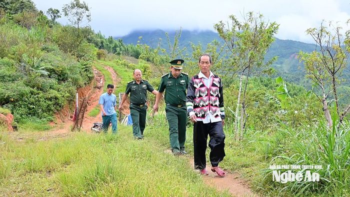 Ông Thò Chứ Hờ - người uy tín bản Pà Khốm cùng cán bộ Đồn Biên phòng Tri Lễ tuyên truyền về Luật Biên phòng. Ảnh: Thành Cường
