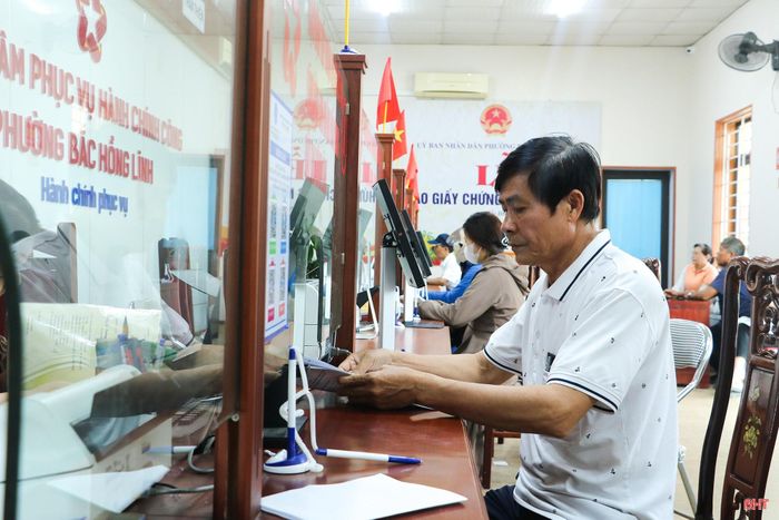 Cán bộ phường Bắc Hồng Lĩnh hướng dẫn ông Nguyễn Bá Tuấn (TDP Hồng Lam, phường Bắc Hồng Lĩnh) thực hiện các thủ tục liên quan đến hồ sơ đất đai.