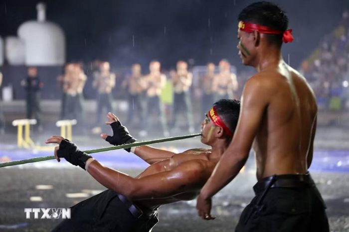 Chiến sỹ đặc nhiệm biểu diễn dùng răng cắn dây kéo xe ôtô hơn 1 tấn. (Ảnh: Trần Lê Lâm/TTXVN)