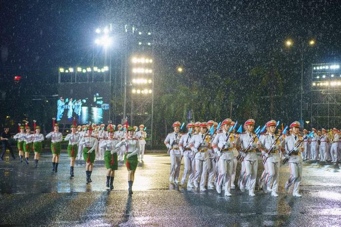 Khối quân nhạc biểu diễn các giai điệu hào hùng cùng những bước đi nhịp nhàng, đều tắp trong màn mưa lớn thu hút sự chú ý của khán đài. (Ảnh: Thanh Phong/Vietnam+)