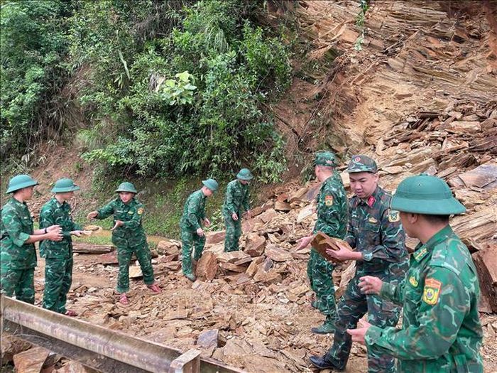 Cán bộ, chiến sĩ Đồn Biên phòng Chiềng On (Ban Chỉ huy Bộ đội Biên phòng tỉnh Sơn La) tiến hành san gạt đất đá để người và các phương tiện lưu thông thuận lợi, đảm bảo an toàn. Ảnh: TTXVN phát