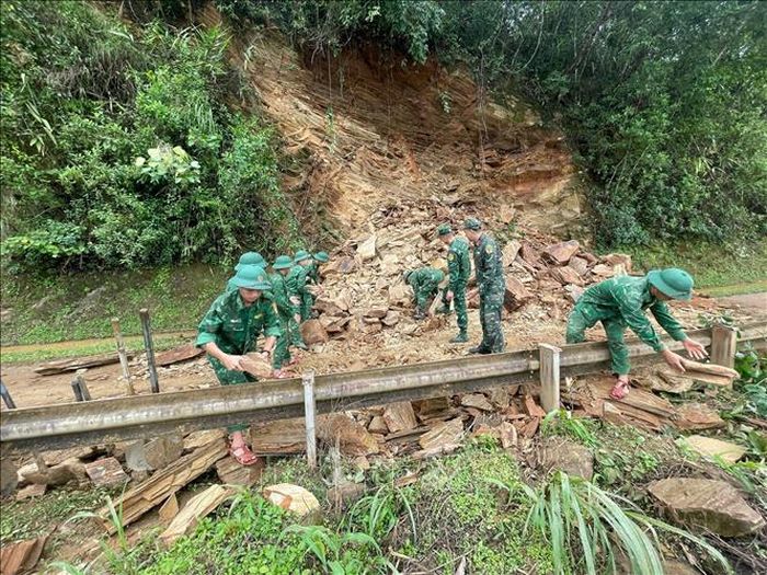 Cán bộ, chiến sĩ Đồn Biên phòng Chiềng On (Ban Chỉ huy Bộ đội Biên phòng tỉnh Sơn La) tiến hành san gạt đất đá để người và các phương tiện lưu thông thuận lợi, đảm bảo an toàn. Ảnh: TTXVN phát