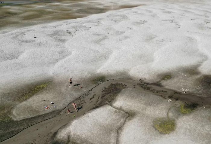 Người dân đi bộ trên những bãi cát mới lộ ra trên sông Danube ở Apatin, Serbia, ngày 29/7. Ảnh: Reuters.