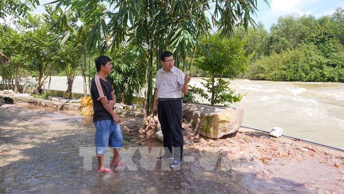Lãnh đạo Chi nhánh Dầu Tiếng - Phước Hòa (Công ty Trách nhiệm hữu hạn Một thành viên Khai thác thủy lợi Miền Nam) trao đổi với người dân về hoạt động kinh doanh tại hành lang thoát lũ hồ Dầu Tiếng. Ảnh: Minh Phú - TTXVN