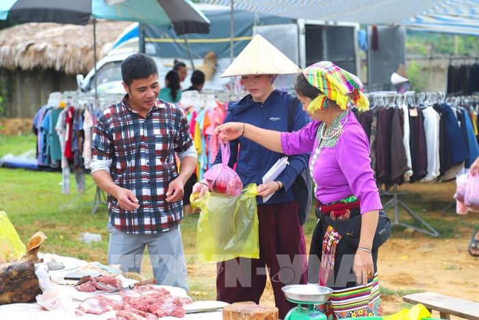 Người phụ nữ là chủ sạp bán thịt mặc trang phục truyền thống trong ngày diễn ra chợ phiên để góp phần quảng bá văn hóa của dân tộc đến người dân, du khách. Ảnh: Xuân Tiến - TTXVN