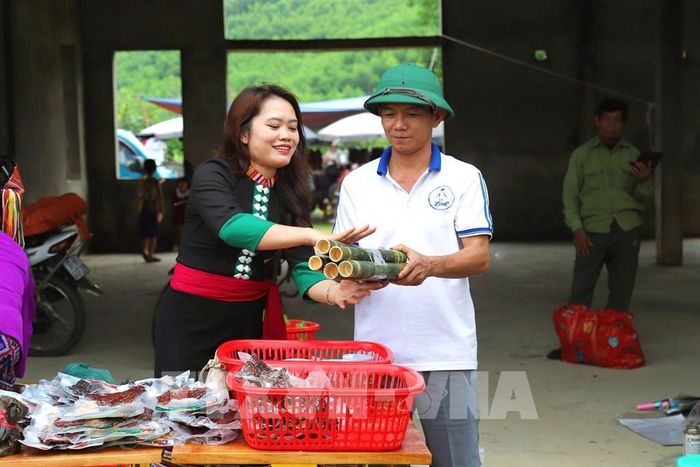 Phụ nữ dân tộc Thái là chủ quày hàng bán các loại sản phẩm thịt sấy khô và ẩm thực truyền thống của đồng bào Thái đang lựa chọn, giao hàng cho khách. Ảnh: Xuân Tiến - TTXVN