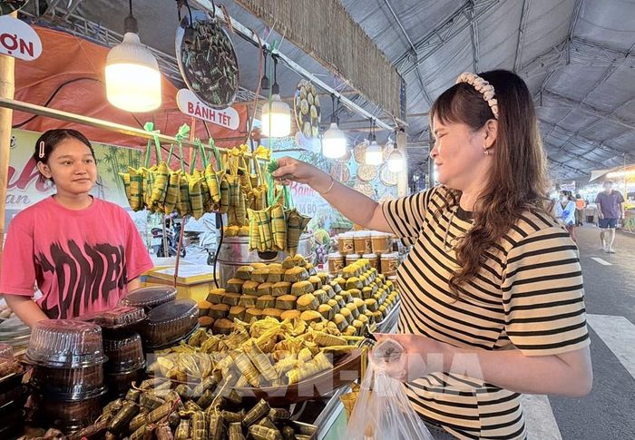 Người dân thích thú với những đòn bánh tét mi ni được trưng bày tại Ngày hội Bánh dân gian Nam Bộ - An Giang 2026. Ảnh: Thanh Sang- TTXVN
