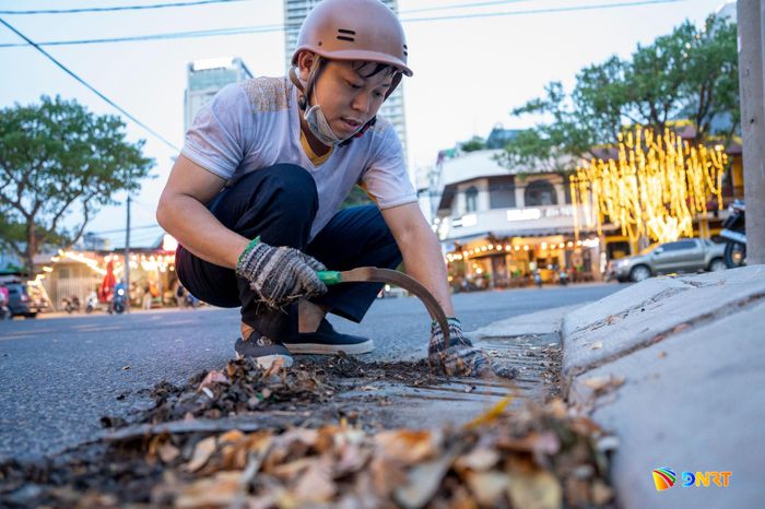 Đỗ Quang Trí khơi thông cống thoát nước mưa tại ngã tư Hồ Nghinh - Lê Thước. Ảnh: HOÀNG SA