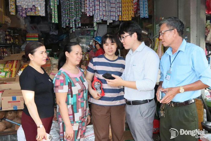 Sau hội nghị, tiểu thương chợ Đồng Xoài được hướng dẫn cài đặt và sử dụng phần mềm chợ thông minh. Ảnh: Quang Minh