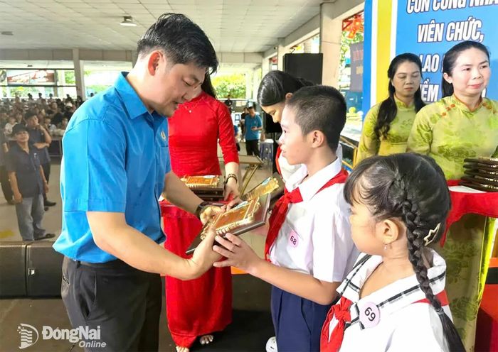 Thành ủy viên, Phó Chủ tịch Ủy ban MTTQ Việt Nam thành phố, Chủ tịch Liên đoàn Lao động thành phố Nguyễn Quốc Dũng trao khen thưởng cho các em học sinh. Ảnh: Nguyễn Hòa
