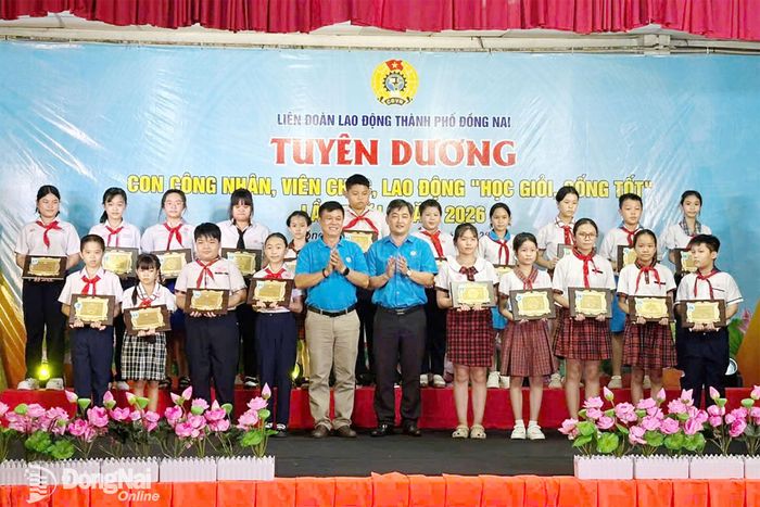 Thành ủy viên, Phó Chủ tịch Ủy ban MTTQ Việt Nam thành phố, Chủ tịch Liên đoàn Lao động thành phố Nguyễn Quốc Dũng và đại diện Công đoàn cơ sở trao khen thưởng cho các em học sinh. Ảnh: Nguyễn Hòa