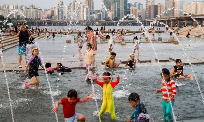  Người dân Hàn Quốc giải nhiệt tại khu vực đài phun nước, ngày 31-7-2026. Ảnh: TTXVN 