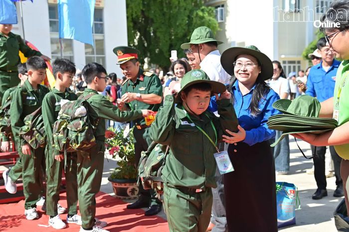 Ban tổ chức đeo thẻ học viên, trao mũ cho các chiến sĩ nhí.