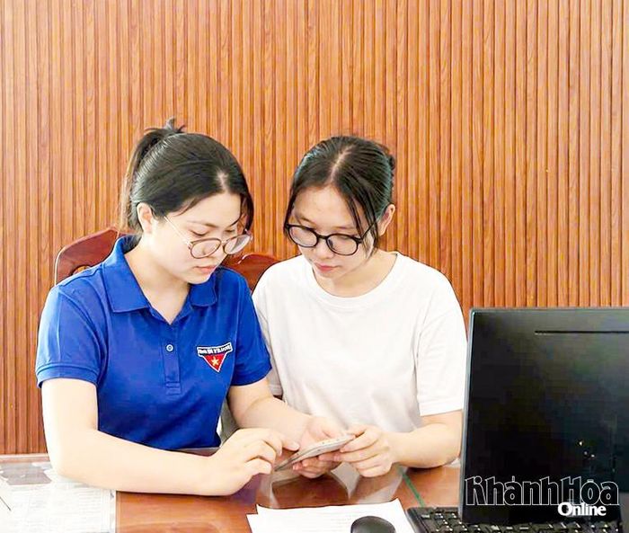Đoàn viên hướng dẫn người dân thực hiện dịch vụ công trực tuyến trên điện thoại thông minh.