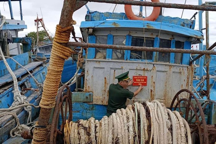 Cán bộ Biên phòng tỉnh tiến hành gắn biển đối với tàu cá không đủ điều kiện hoạt động