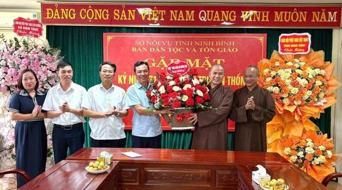 Thượng tọa Thích Thanh Huy, Trưởng ban Đại diện Phật giáo liên xã Vụ Bản tặng hoa chúc mừng