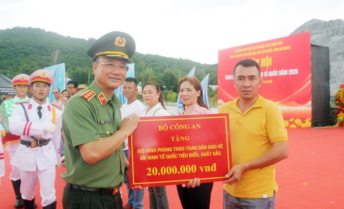 Thứ trưởng Phạm Thế Tùng trao quà của Bộ Công an tặng đại diện của Mô hình phong trào TDBV ANTQ tiêu biểu, xuất sắc.