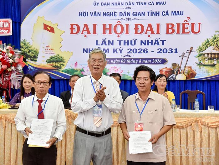 Ông Trương Thanh Hùng, Ủy viên Ban Chấp hành Hội Văn nghệ dân gian Việt Nam, trao quyết định kết nạp hai hội viên mới.