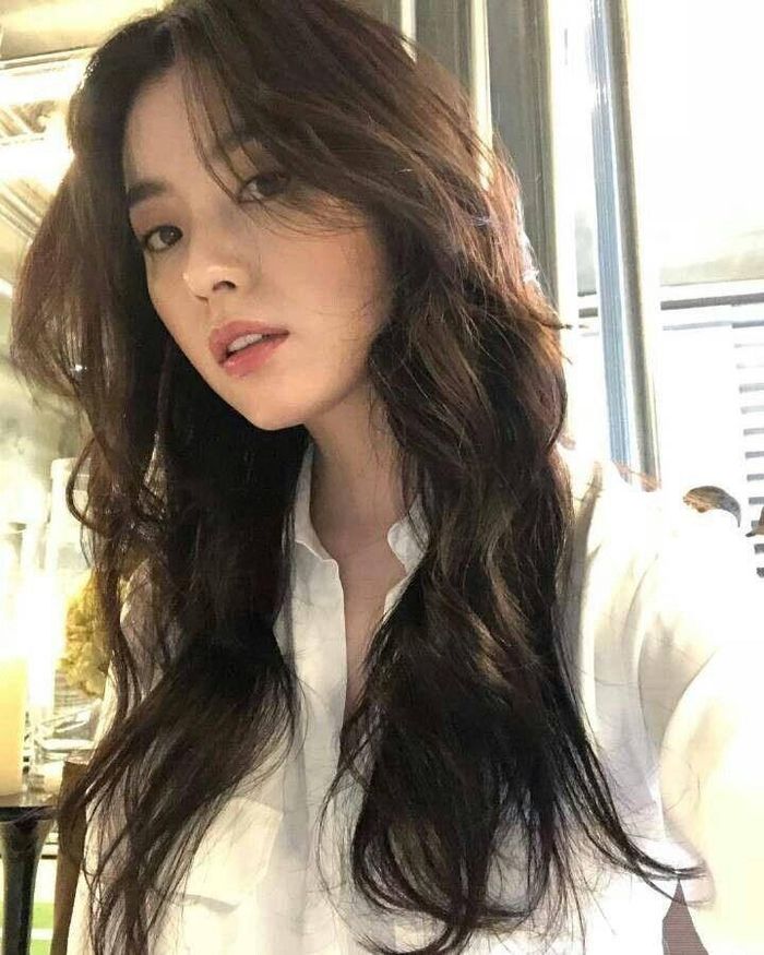 Tóc dài uốn sóng lơi giúp áo sơ mi thêm phần nữ tính, mềm mại.