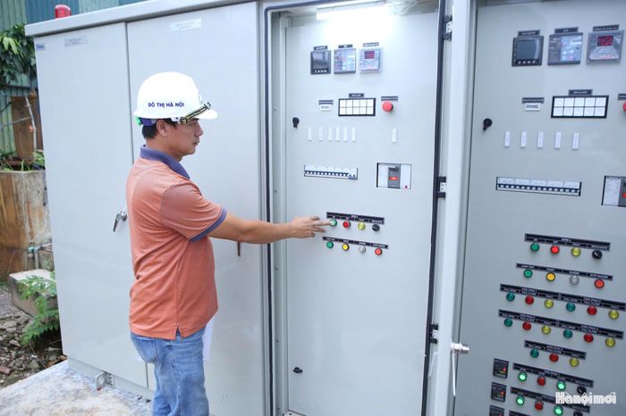 Cán bộ vận hành hệ thống tại trạm bơm Cầu Ngà trong trận mưa ngày 27-7. Ảnh: Duy Khánh