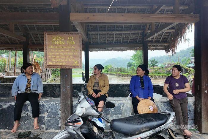 Người dân trò chuyện bên giếng cổ thôn Tha. Ảnh: T. Anh