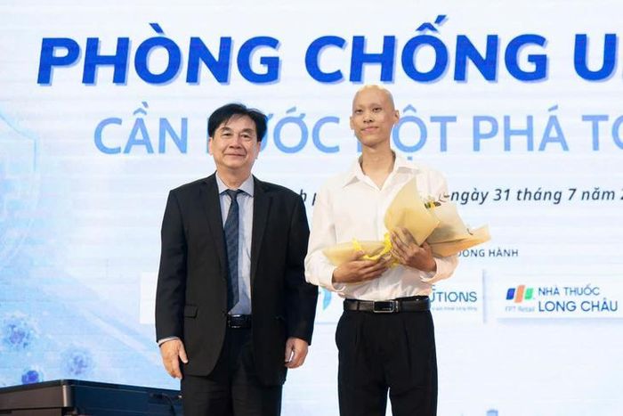 Thầy thuốc Nhân dân, TS.BS.CKII Phạm Xuân Dũng - Phó chủ tịch Hội Ung thư Việt Nam, Chủ tịch Hội Ung thư TPHCM tặng hoa cho chàng trai Lý Đại Phước tại một hội thảo ung thư. Ảnh: V.Sơn