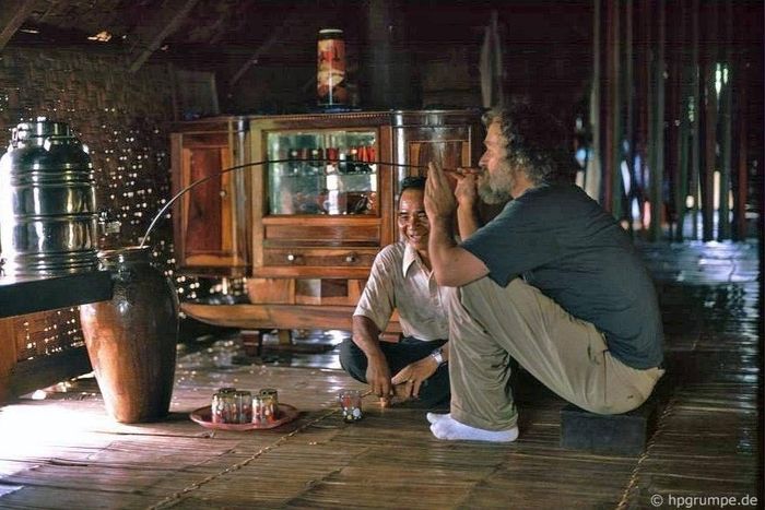  Hans-Peter Grumpe uống rượu cần bằng ống hút dài trong buổi đón tiếp của gia đình ông Mamahrine tại làng Ê Đê Ko Dhong, gần Buôn Ma Thuột, năm 1992. 