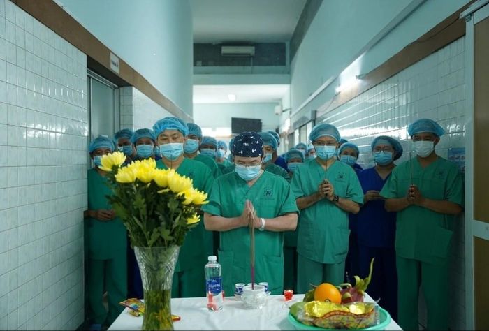 Các bác sĩ cúi đầu, dành một phút mặc niệm trước khi bắt đầu ca phẫu thuật lấy tạng tại Bệnh viện Thống Nhất. Ảnh: Phan Pháp.