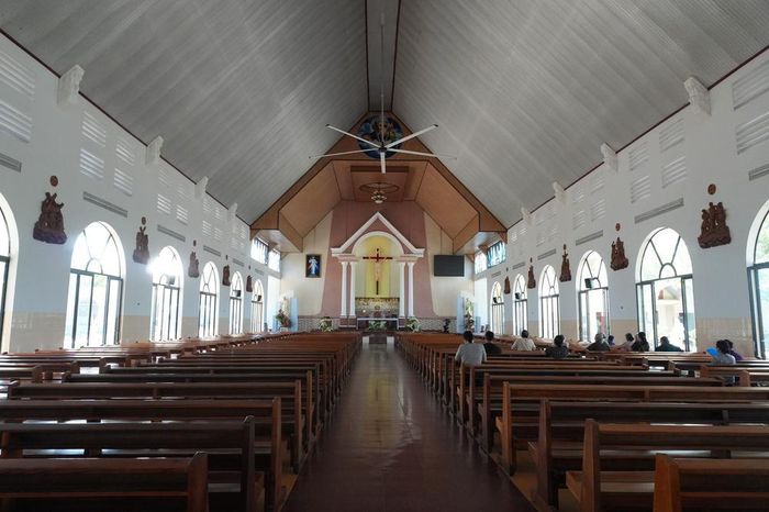 Người dân làng Tân Hà đi lễ tại Nhà thờ Tân Hà, công trình nằm trong trung tâm của ngôi làng hình bát quái. Ảnh: Nguyễn Dũng – TTXVN
