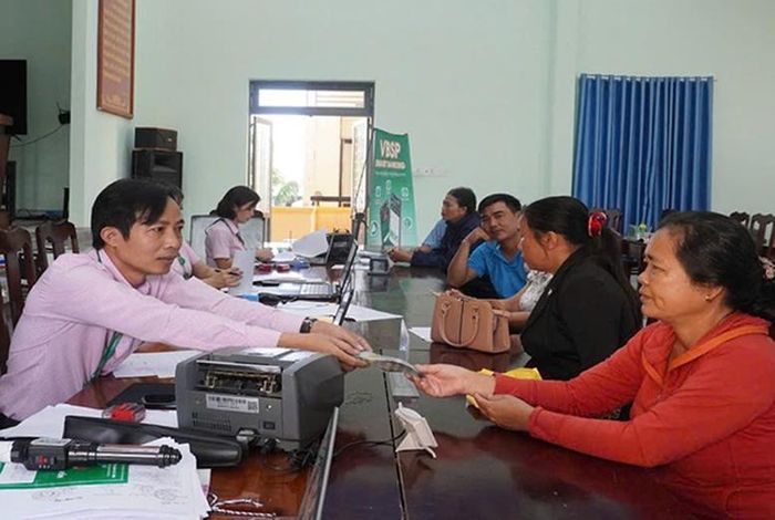 Cán bộ Phòng giao dịch NHCSXH Bình Sơn giải ngân vốn vay ưu đãi tại điểm giao dịch - Ảnh: vbsp.org.vn