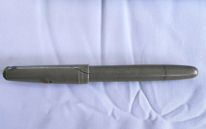 Chiếc bút nằm cùng hài cốt liệt sĩ tại ngôi mộ số 23. Ảnh: MINH KHÁNH
