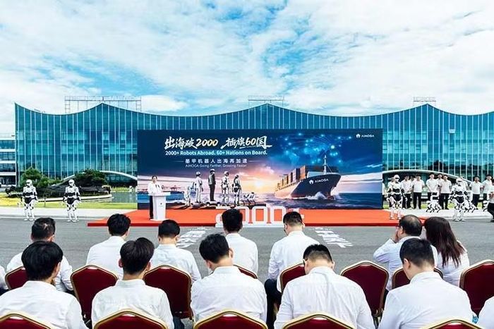 Tại buổi lễ, hàng loạt robot AiMOGA đồng loạt cầm quốc kỳ của hơn 60 quốc gia và vùng lãnh thổ khi đoàn xe vận chuyển chuẩn bị xuất phát đến cảng Vu Hồ để giao lô hàng mới ra thị trường quốc tế.