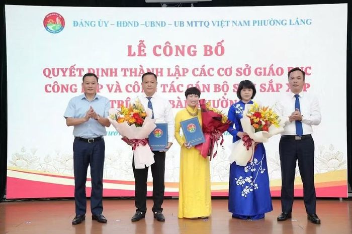 Lãnh đạo phường Láng trao quyết định, tặng hoa chúc mừng ông Nguyễn Trung Kiên - tân Hiệu trưởng Trường Liên cấp Huỳnh Thúc Kháng (thứ 2 từ trái sang).