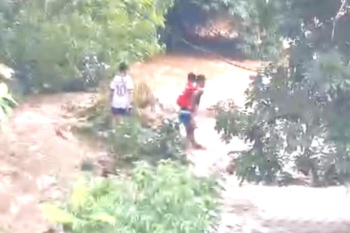 Anh Kiên đưa hai em nhỏ vượt dòng lũ vào bờ an toàn.