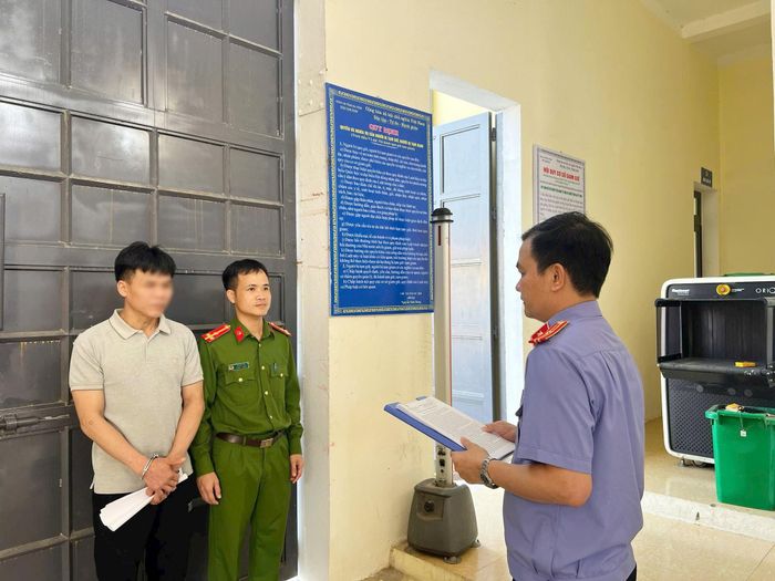 Hình ảnh kiểm sát viên và điều tra viên tống đạt các quyết định tố tụng đối với bị can Nguyễn Trung Thành.