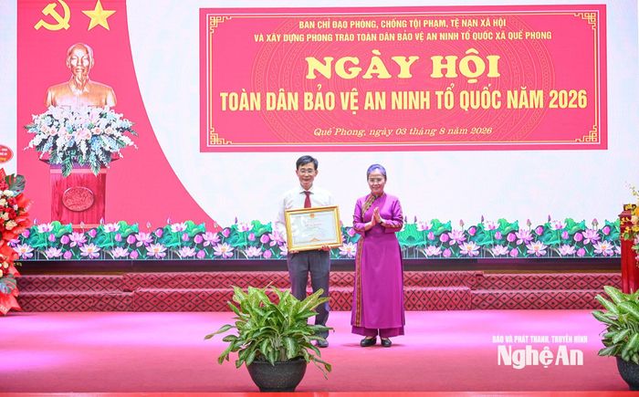 Thay mặt Chủ tịch UBND tỉnh, đồng chí Võ Thị Minh Sinh trao Bằng khen cho đồng chí Trương Minh Cương - Bí thư Đảng ủy xã Quế Phong vì đã có thành tích trong bảo vệ an ninh Tổ quốc. Ảnh: Thành Cường