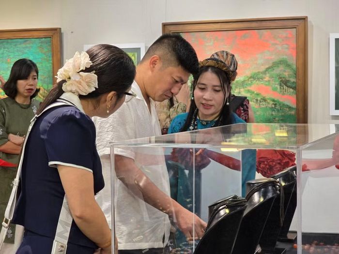 Hồ Dương (áo xanh) chia sẻ về loại đá chị nhiều năm nghiên cứu, sưu tầm. (Ảnh: Minh Anh/Vietnam+)