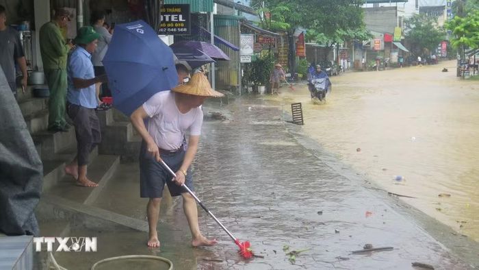Người dân tổ 4 Duyên Hải, phường Lào Cai dọn dẹp nhà cửa sau ngập úng. (Ảnh: Hương Thu/TTXVN)