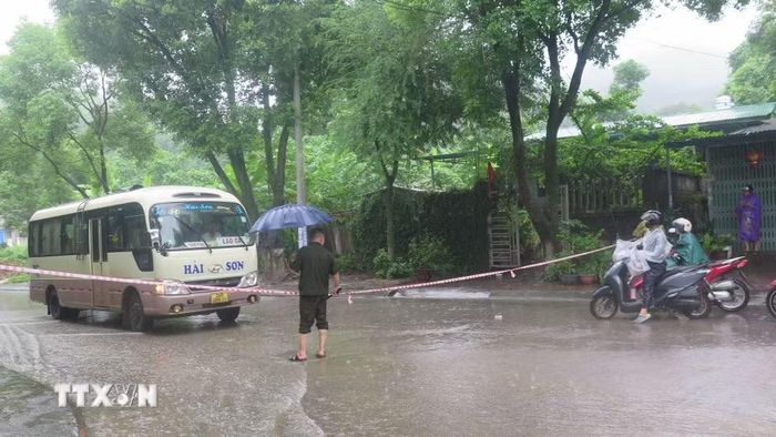 Lực lượng chức năng căng dây cảnh báo, phân luồng giao thông tại các tuyến đường bị ngập úng của phường Lào Cai. (Ảnh: Hương Thu/TTXVN)