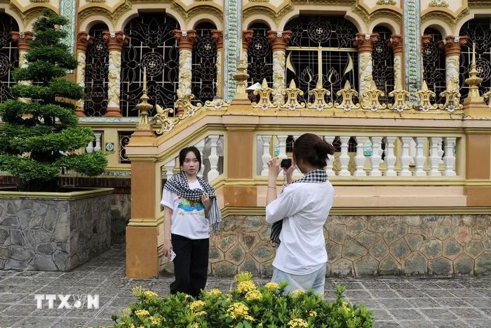 Du khách ghi lại hình ảnh lưu niệm tại ngôi chùa gần 200 năm tuổi. (Ảnh: Hồng Thái/TTXVN)