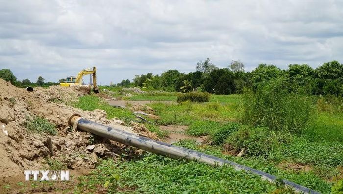 Công trình cao tốc đang thi công khiến nông dân gặp khó về tưới tiêu, không có đường cho máy móc vào đồng ruộng. (Ảnh: Nhựt An/TTXVN)