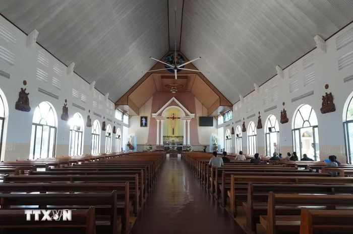 Người dân làng Tân Hà đi lễ tại Nhà thờ Tân Hà, công trình nằm trong trung tâm của ngôi làng hình bát quái. (Ảnh: Nguyễn Dũng/TTXVN)