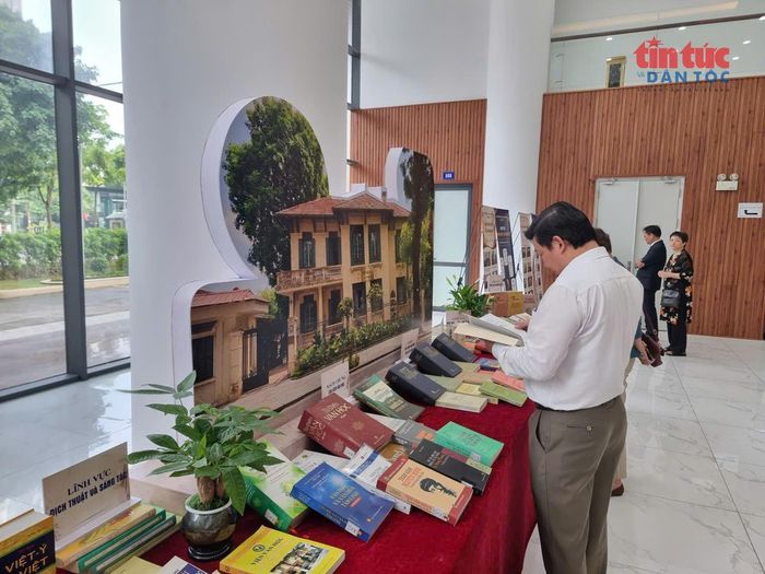 Các đại biểu, nhà nghiên cứu đọc sách tại khu vực trưng bày.
