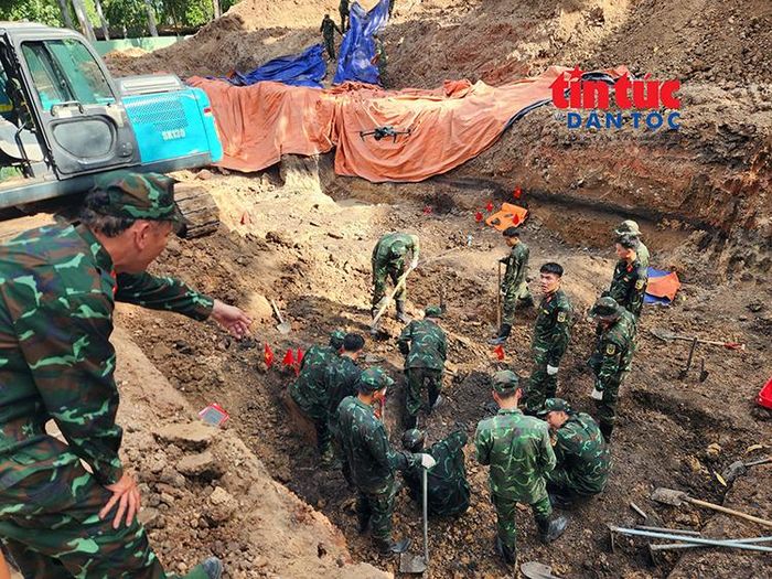 Trung tá Lê Ngọc Hà, Đội trưởng Đội K74 đứng từ trên cao hướng dẫn lực lượng phía dưới cẩn thận tìm kiếm, cất bốc hài cốt liệt sĩ.
