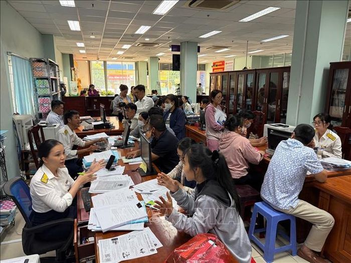 Cán bộ Thuế Cơ sở 12 (thuộc Thuế TP. Hồ Chí Minh) tập trung giải đáp các vướng mắc cho hộ kinh doanh trước thời điểm chuyển đổi mô hình quản lý thuế. Ảnh tư liệu: Hứa Chung/TTXVN