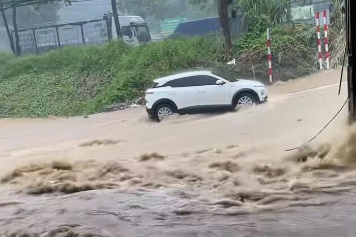 Hình ảnh chiếc ô tô điện cố vượt dòng nước lũ (Ảnh: Lào Cai/ Cắt từ clip).