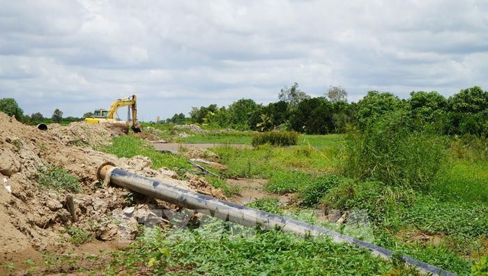 Công trình cao tốc đang thi công khiến nông dân gặp khó về tưới tiêu, không có đường cho máy móc vào đồng ruộng. Ảnh: Nhựt An - TTXVN