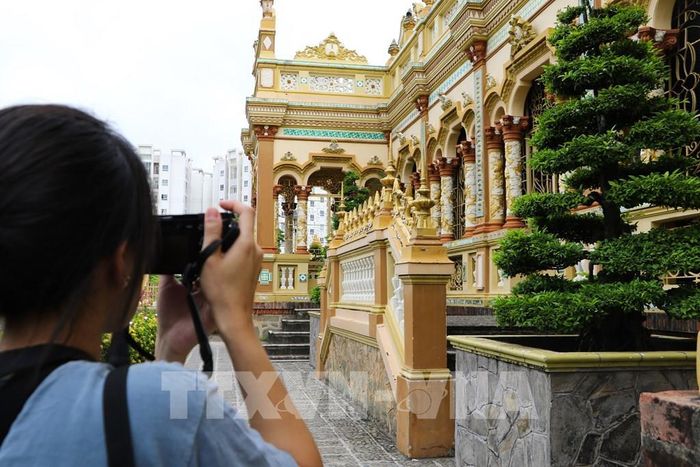Du khách ghi lại những hình ảnh của chùa Vĩnh Tràng. Ảnh: Hồng Thái - TTXVN